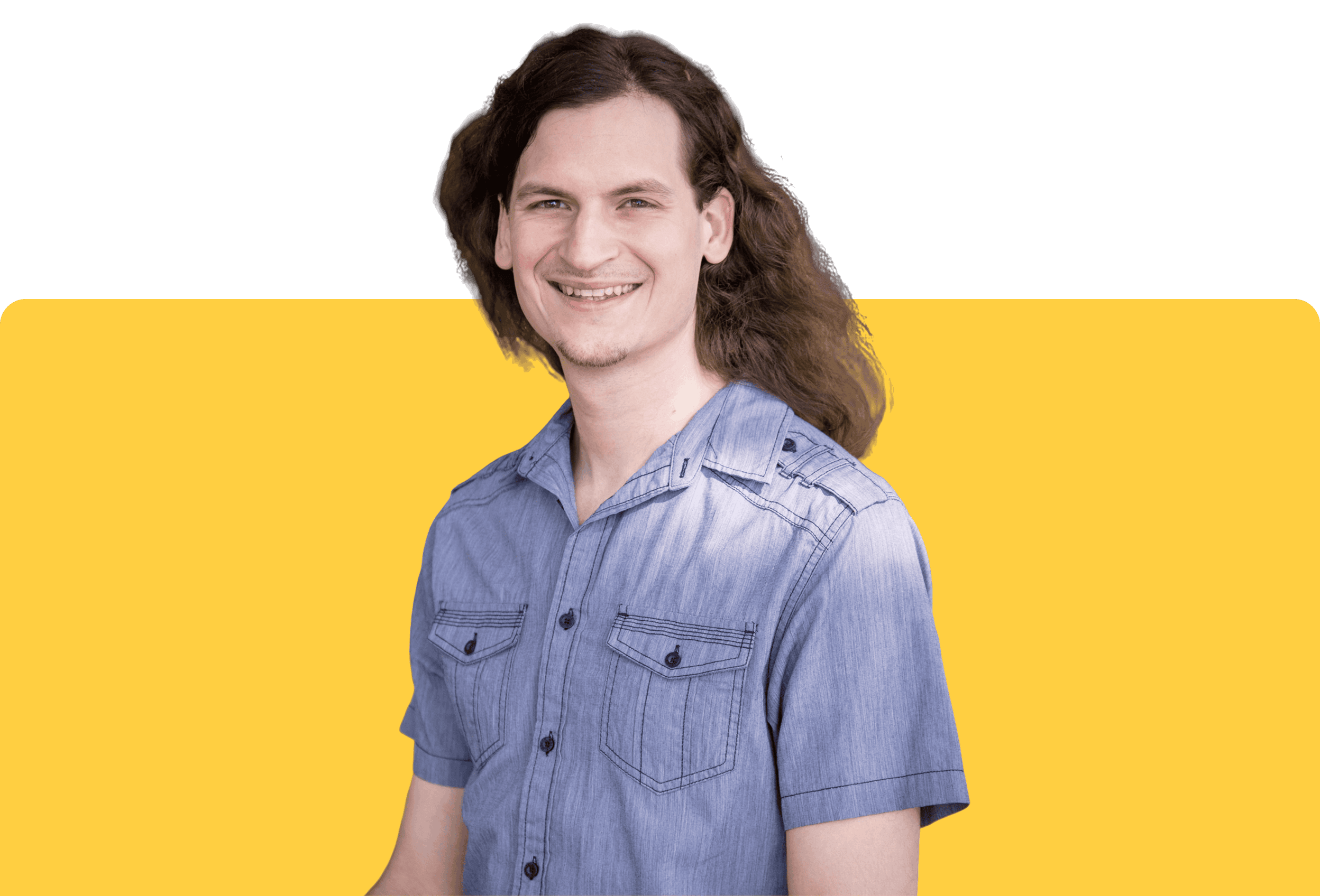 Happy young man with long, wavy hair, smiling confidently, dressed in a casual blue shirt against a vibrant yellow background.